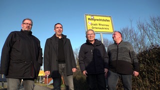 Hans Frei (3. v.l.) steht mit seinen Söhnen vor dem Ortsschild mit dem Aufdruck Memprechtshofen. Die vier singen gemeinsam in einem Chor.