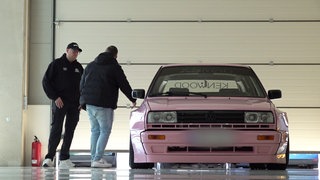 Daniel Kampmann mit Kunden stehen neben einem pinken VW.