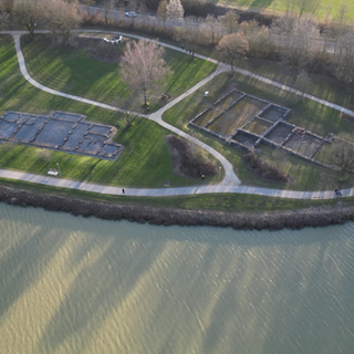 Aus der Vogelperspektive ist eine Ausgrabungsstätte aus der Römerzeit zu sehen. Die Umrisse der Grundmauern lassen sich erkennen. 