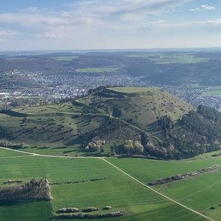 Der grüne Berg Ipf ist in der Bildmitte. Dahinter erstreckt sich die Stadt Bopfingen.