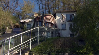 Ein Haus mit einer organische, mit einem rostroten Muster versehenem Element an der Fassade. 
