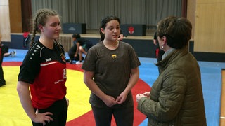 Sonja Faber-Schreklein besucht die Ringer in Ebersbach. Sie spricht mit zwei jungen Ringerinnen.