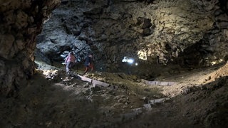 Zwei Besucher in der Unesco-Welterbe-Höhle Hohle Fels bei Schelklingen