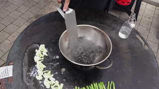 Pasta werden im Wok auf einem Grill gekocht