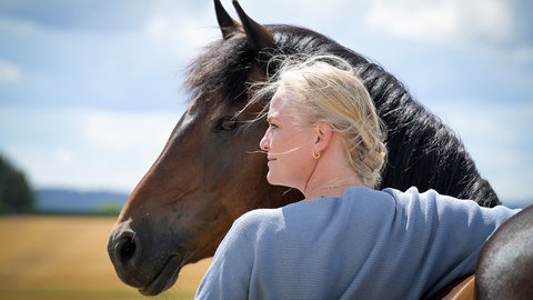 Pferdetrainerin Yvonne Gutsche steht vor einem Pferd.