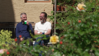 Stefan Lipka und Martin Wünsche sitzen in ihrem Garten und genießen ein Getränk und den Anblick ihrer Arbeit.