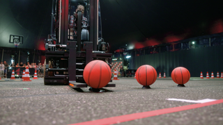 Ein Stapler trasportiert geschickt einen Basketball.