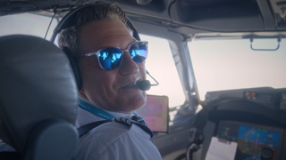 Pilot sitzt mit Sonnenbrille im Cockpit