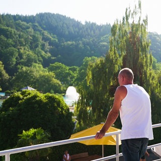 Michael Lorenz steht auf dem Balkon seiner Wohnung im Strandbad Freiburg und schaut in die Ferne über das Gelände.