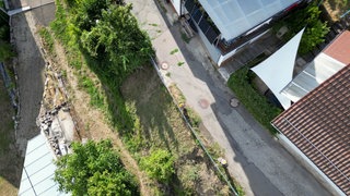 Eine marode Straße in Mühringen. Sie ist an einem Hang gelegen, und man erkennt, dass der Hang absackt.