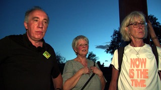 Eine Gruppe Menschen steht in der Dämmerung auf dem Birkenkopf, auch bekannt als Monte Scherbelino, in Stuttgart.