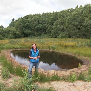 Wetter-Reporterin Ulrike Nehrbaß steht vor einem kleinen Teich