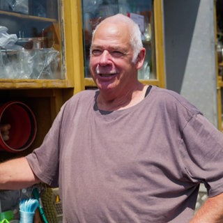 Mann steht vor einem fahrenden Händlerwagen