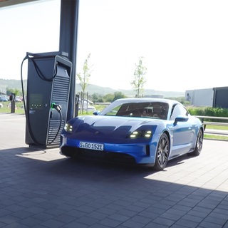 Porsche steht an eine E-Lade Säule.