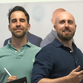 Zwei Männer stehen vor einer Wand