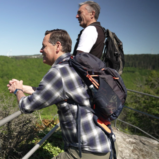 Holger Wienpahl und Michael Meiss blicken über einen Wald auf der Hunolsteiner Klammtour.