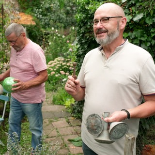 Zwei Männer stehen im Garten