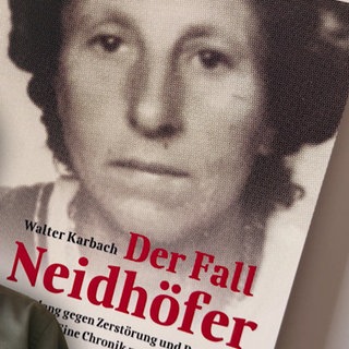 Mann mit einem Buch im Hintergrund