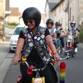 Eine Frau fährt Mofa auf einer Straße