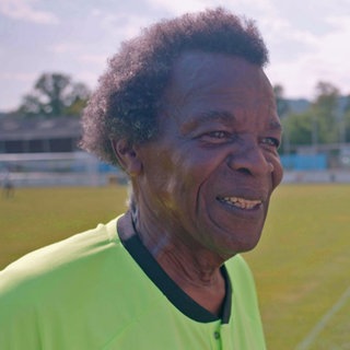 Schiedsrichter steht auf einem Fußballfeld.