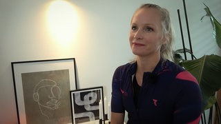 Sitzende Frau in Sportkleidung