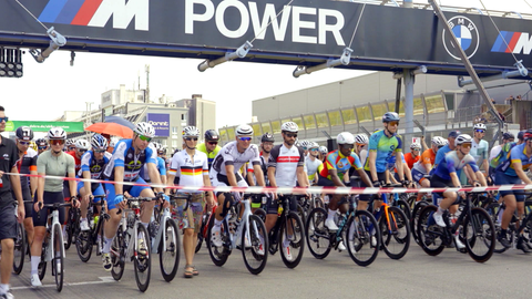 Zahlreiche Radfahrer*innen an der stehen an der Startlinie für das Fahrradrennen des "Rad am Ring" bereit.