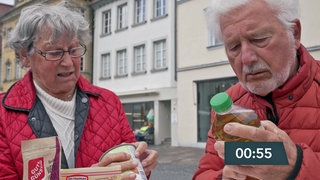 Zwei Menschen suchen das Mindesthaltbarkeitsdatum auf Produkten