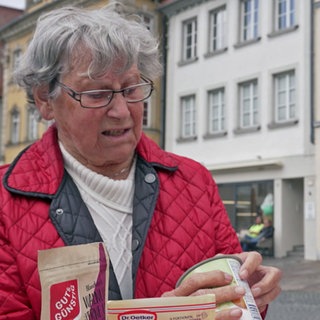 Zwei Menschen suchen das Mindesthaltbarkeitsdatum auf Produkten
