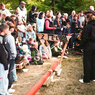 Menschen stehen am Ziel einer Murmelbahn