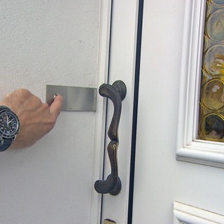 Finger drückt auf Klingel an einer Tür