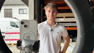 Felix Schröder steht vor seinem Smartphone