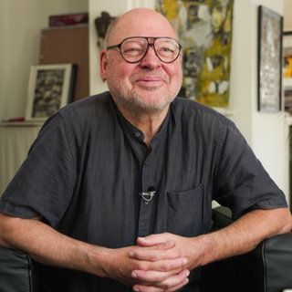 Mann sitzt in seinem Wohnzimmer