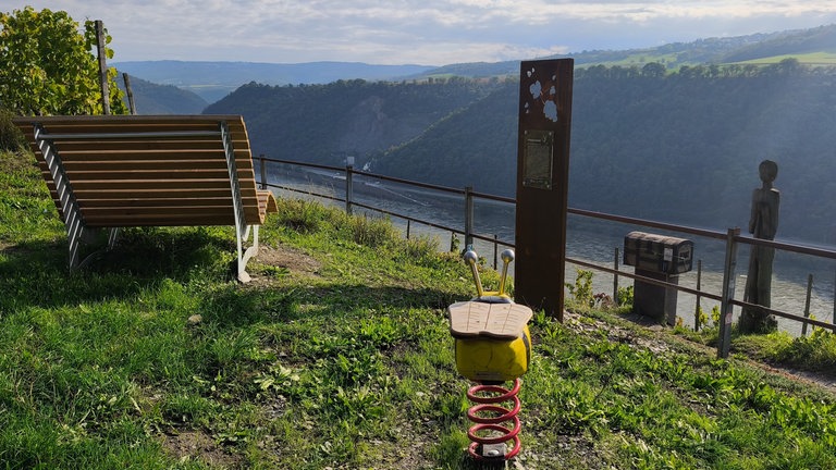 Holzliegen, Infotafeln und Spielgeräte auf dem Rheinsteig Wanderweg.