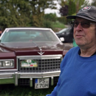 Cadillac-Besitzer vor seinem Auto beim Oldtimer-Wandern in der Südpfalz