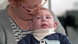 Krnakes Kleinkind Paul auf dem Arm seiner Mutter Anna Mack