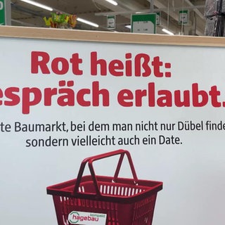 Ein Schild im Baumarkt lädt Leute zum Kennenlernen per Einkaufskorbfarbe ein