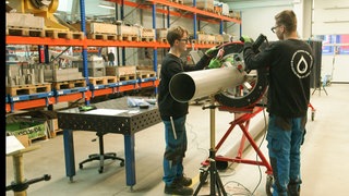 Zwei Mitarbeiter der ZAHNEN TECHNIK arbeiten in der Werkstatt.