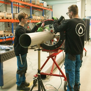 Zwei Mitarbeiter der ZAHNEN TECHNIK arbeiten in der Werkstatt.