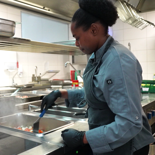 Nadine Uwamahoro brät Gemüse an.