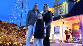 Familie Ripp vor ihrem weihnachtlich geschmückten Haus.