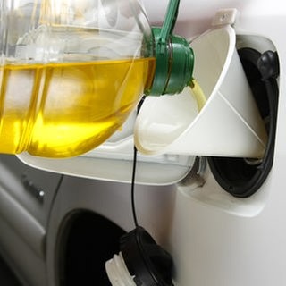 Auto wird mit Speiseöl aus einer Plastikflasche betankt