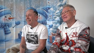 Logopäde Peter und Lesetrainer Jürgen Hallermann vor weihnachtlichem Hintergrund