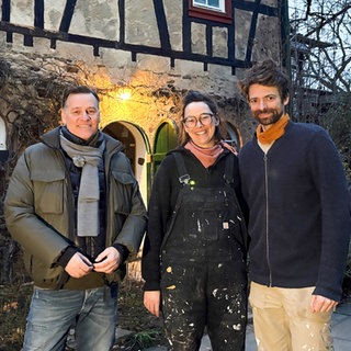 Holger Wienpahl steht mit Clara und Tobias Dorn vor ihrem alten Weingut in Unkel.