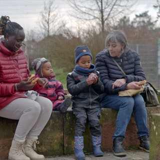 Leih-Oma Astrid Hütter mit Irene Akongo und ihren Kindern auf einem Spielplatz