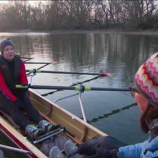5 Personen sitzen in einem Ruderboot auf dem Wasser
