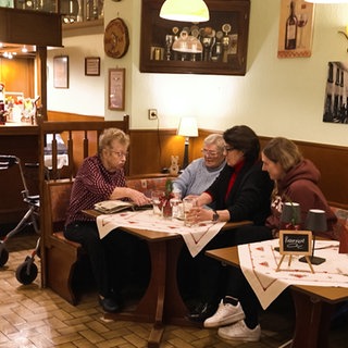 Innenraum eines Landgasthofs mit Personen am Tisch