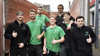 Das junge Team der Entrümplungsfirma Diamclean steht vor einer Hauswand.