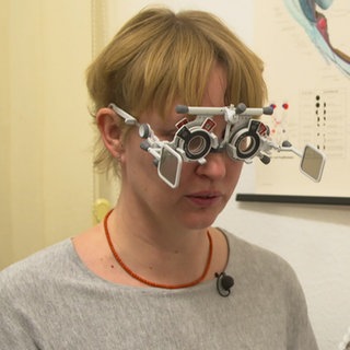 Frau mit einer Optiker, dessen Brillenstärke gerade gemessen wird