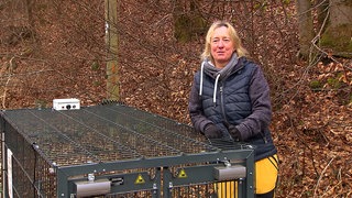 Frau mit einem Käfig im Wald