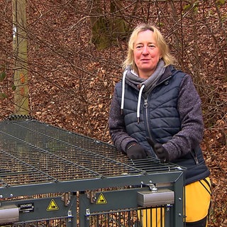 Frau mit einem Käfig im Wald